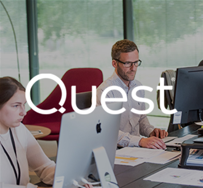 Quest: two people sitting next to each other at table, working on their computers
